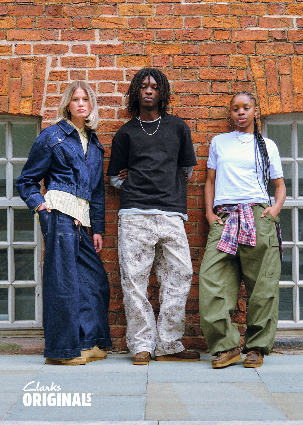 Three people in Clarks Originals against a brick wall